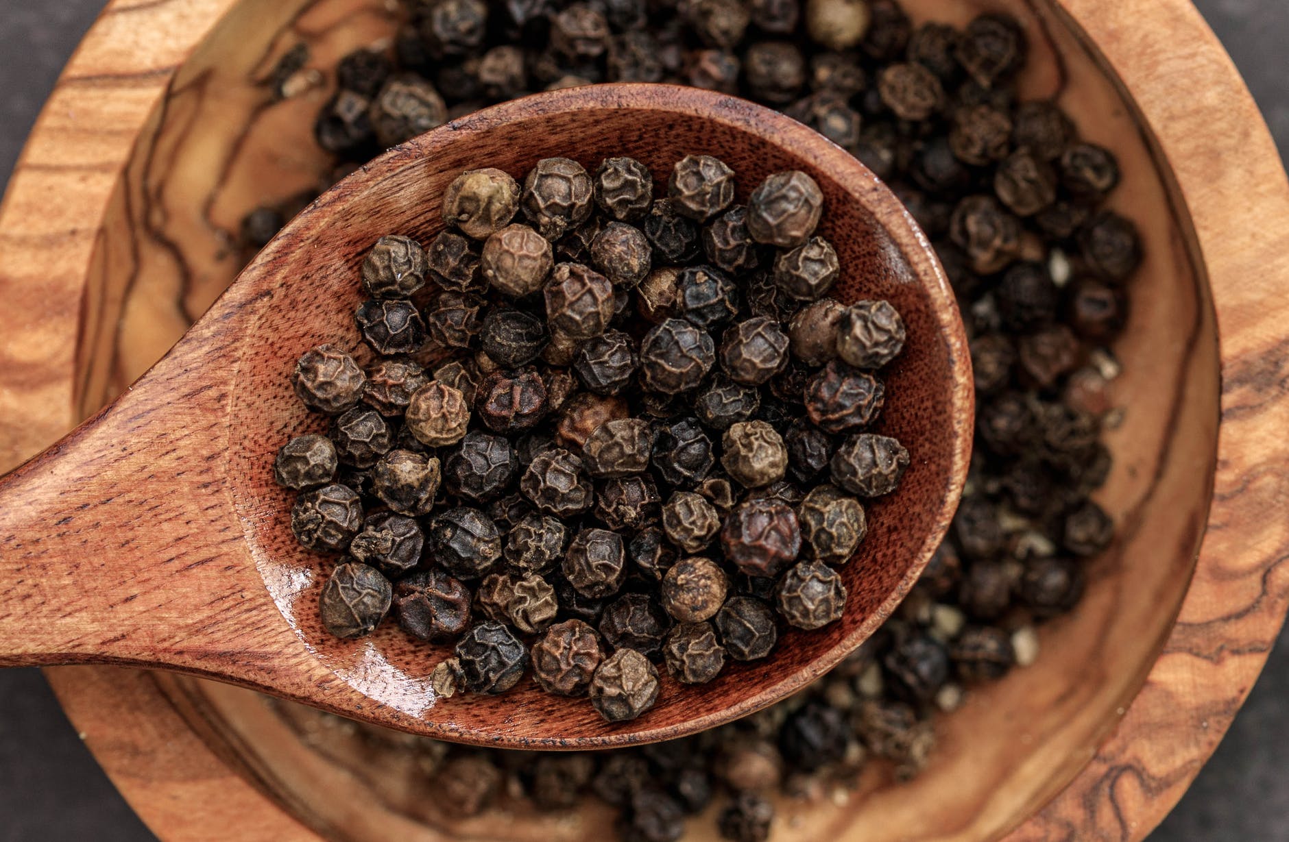 close up shot of black peppers on a spoon